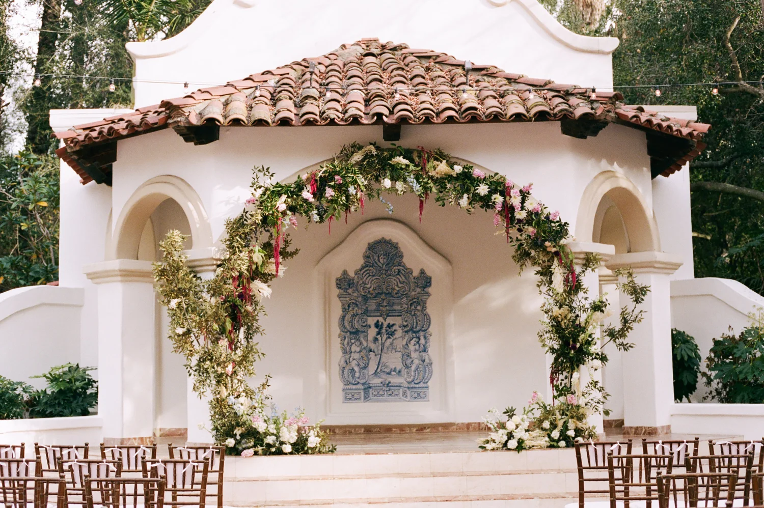 Spanish-style chapel ceremony arch with roses by Pavan Floral
