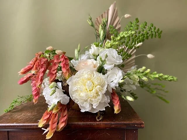 Autumnal centerpiece with white blooms and warm foliage