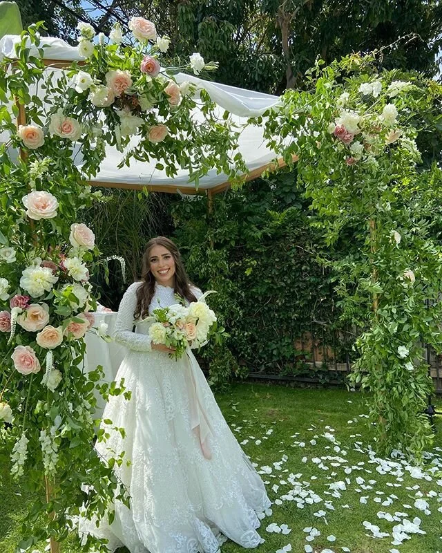 Lush garden ceremony arch with a bride