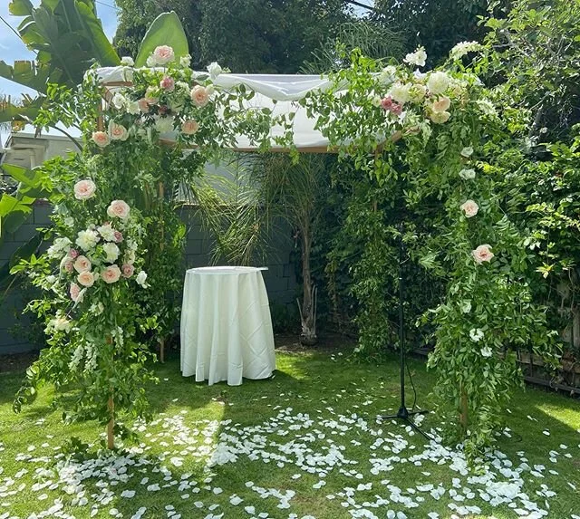 Green garden ceremony arch and petal aisle