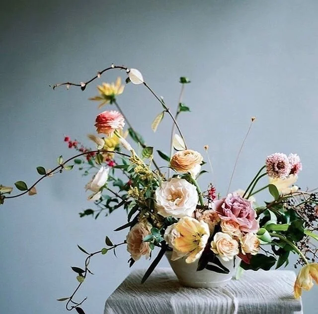 Sculptural European-style arrangement against a blue wall