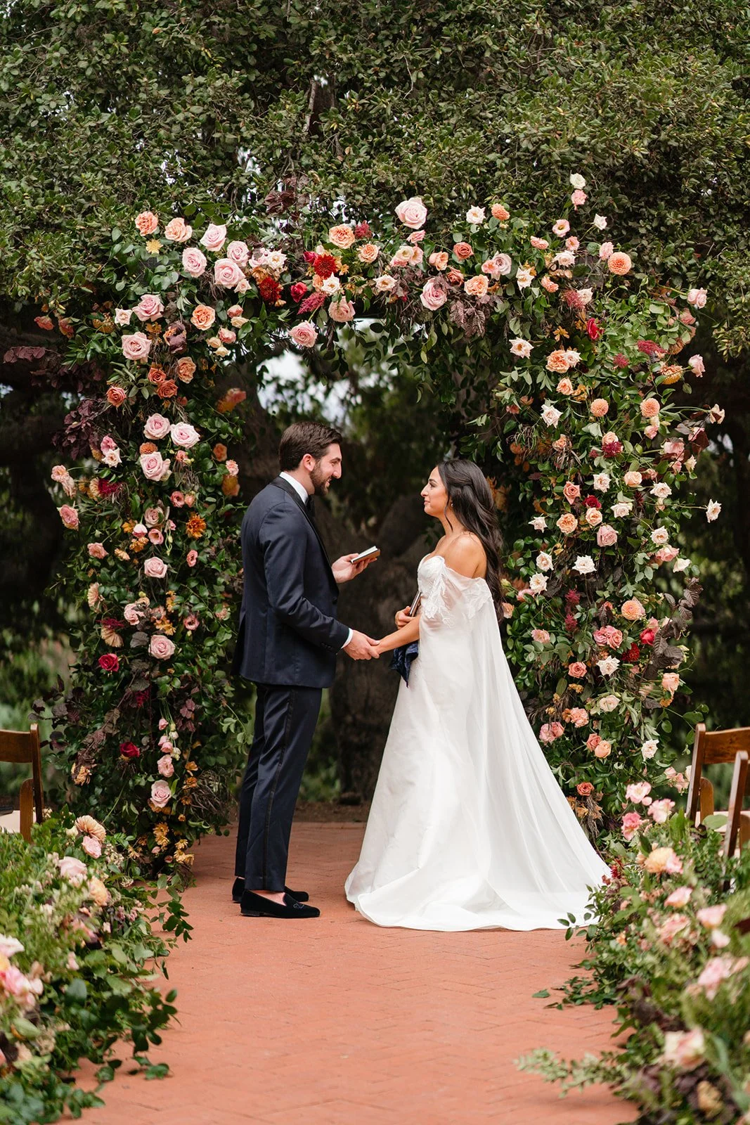 Garden rose ceremony arch with the couple